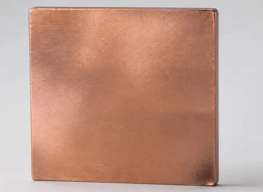 Project-supplied copper-tone square sample photographed against a neutral background