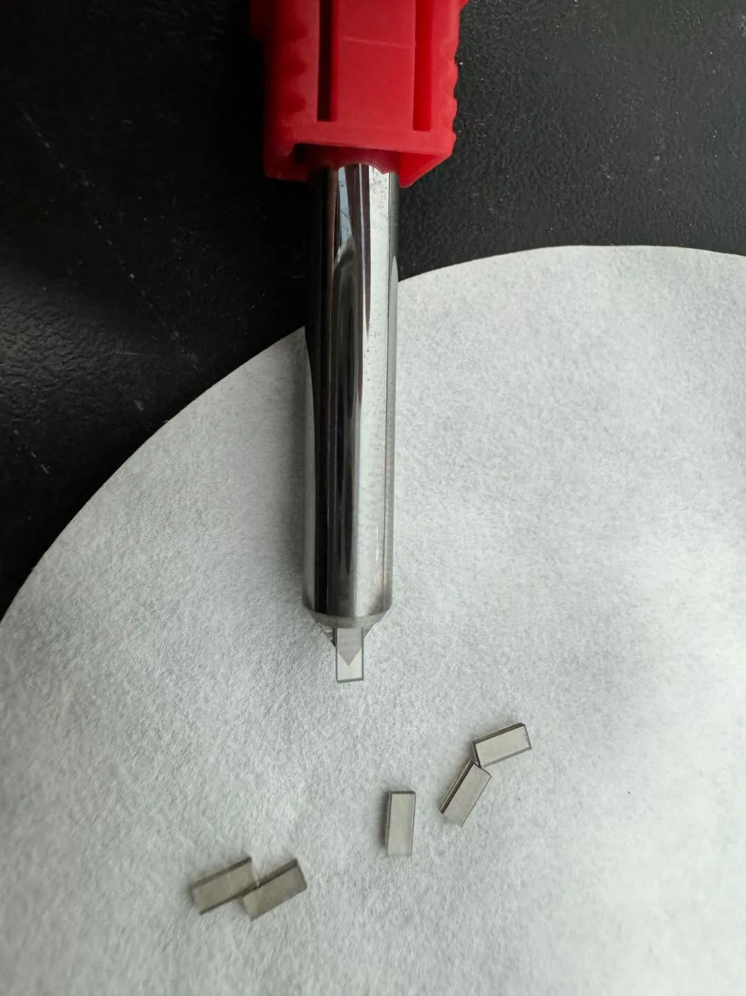 Project-supplied image showing small grey rectangular samples beside a visible hand tool