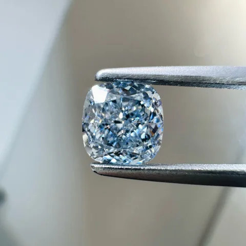 Blue cushion diamond held in tweezers, supplied photograph