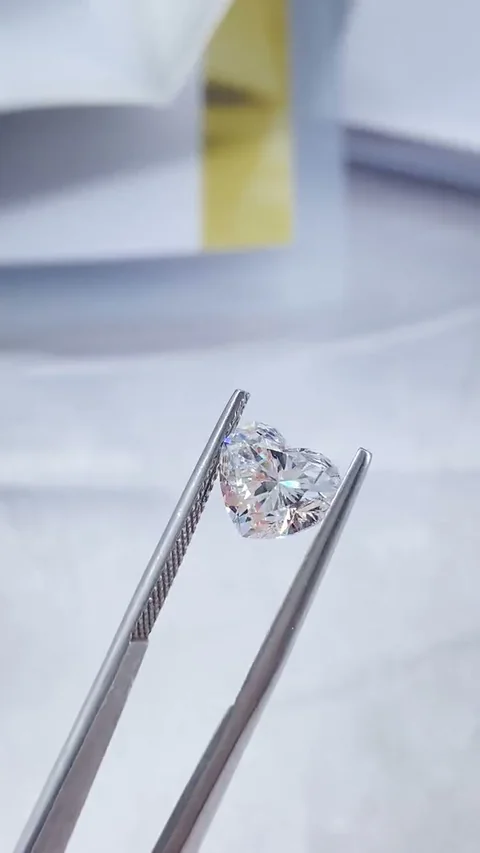 Heart white diamond held in tweezers, extracted from supplied video