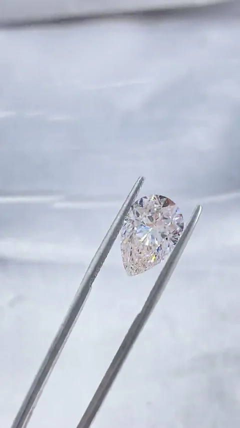 Pear white diamond held in tweezers, extracted from supplied video