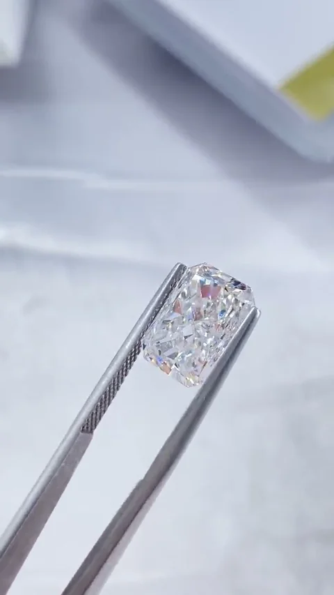 Radiant white diamond held in tweezers, extracted from supplied video