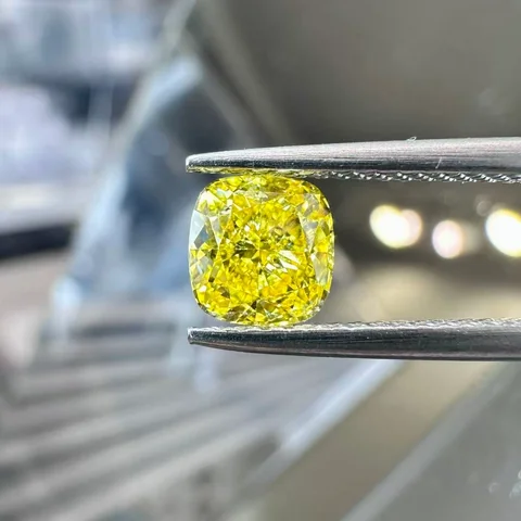 Yellow cushion diamond held in tweezers, supplied photograph