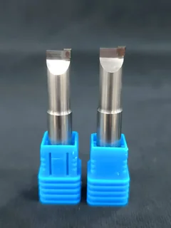 Two DiamovaLab single-crystal diamond end mills in blue protective holders